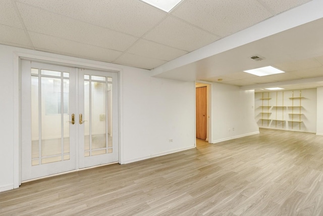 1714 Daybreak Ln, Zion, IL 60099 - empty room with a drop ceiling, light wood-type flooring, french doors, and baseboards