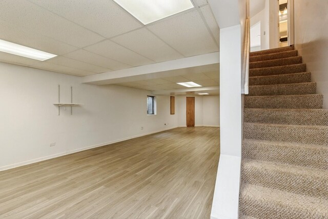 1714 Daybreak Ln, Zion, IL 60099 - below grade area featuring stairs, light wood-type flooring, a paneled ceiling, and baseboards