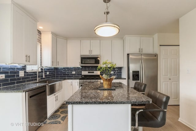 1714 Daybreak Ln, Zion, IL 60099 - kitchen featuring stainless steel appliances, a sink, a breakfast bar, light wood finished floors, and a kitchen island
