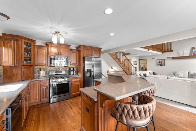 373 W Joliet Hwy, New Lenox, IL 60451 - kitchen featuring appliances with stainless steel finishes, brown cabinetry, a breakfast bar area, a center island, and open floor plan