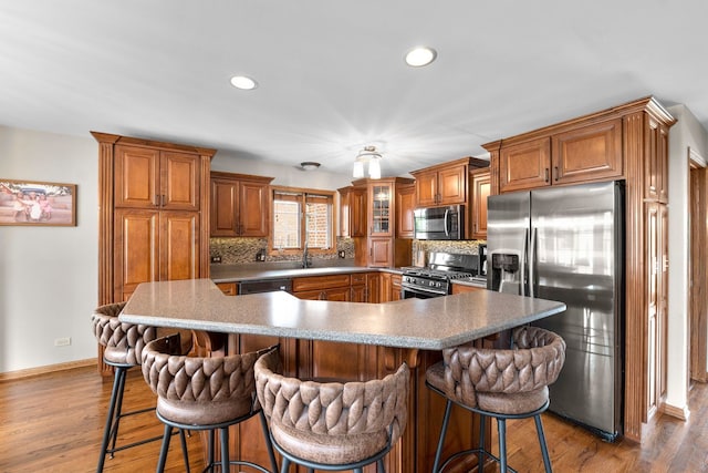 373 W Joliet Hwy, New Lenox, IL 60451 - kitchen with appliances with stainless steel finishes, brown cabinetry, decorative backsplash, recessed lighting, and wood finished floors