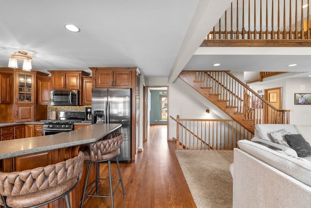 373 W Joliet Hwy, New Lenox, IL 60451 - kitchen with appliances with stainless steel finishes, brown cabinetry, a kitchen bar, dark wood finished floors, and open floor plan