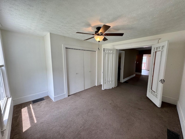 1303 W Locust St, Bloomington, IL 61701 - unfurnished bedroom with carpet floors, a textured ceiling, a closet, and baseboards