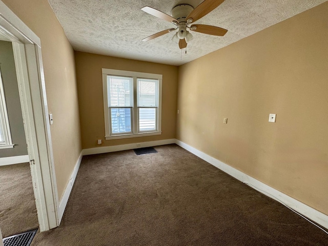 1303 W Locust St, Bloomington, IL 61701 - unfurnished room featuring dark colored carpet, ceiling fan, a textured ceiling, and baseboards