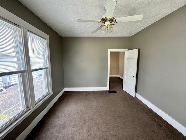 1303 W Locust St, Bloomington, IL 61701 - spare room with a textured ceiling, baseboards, dark colored carpet, and a ceiling fan
