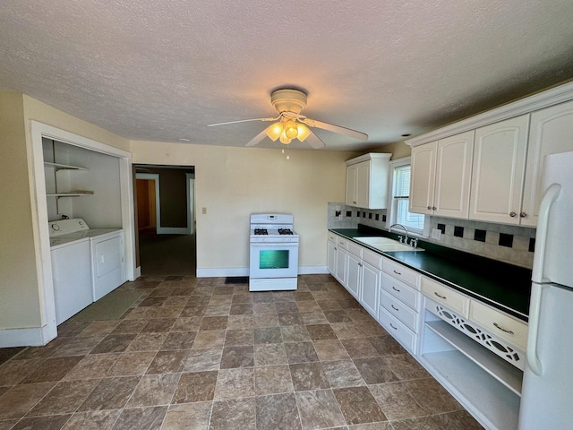 1303 W Locust St, Bloomington, IL 61701 - kitchen featuring white appliances, washing machine and dryer, a sink, baseboards, and white cabinets