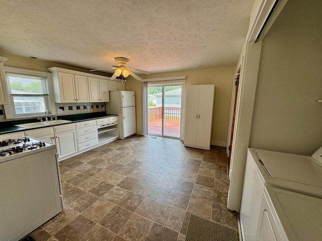 1303 W Locust St, Bloomington, IL 61701 - kitchen with washing machine and clothes dryer, a sink, white appliances, ceiling fan, and stone finish floors