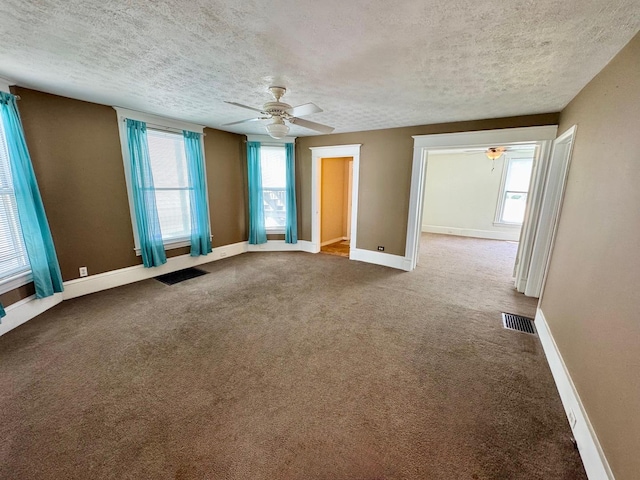1303 W Locust St, Bloomington, IL 61701 - spare room featuring ceiling fan, a textured ceiling, carpet, and baseboards