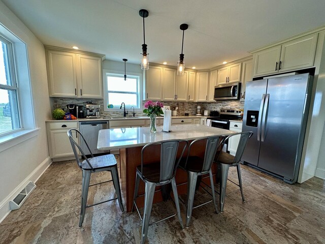 2034 Gittleson Rd, Rochelle, IL 61068 - kitchen with appliances with stainless steel finishes, a sink, tasteful backsplash, and a kitchen island