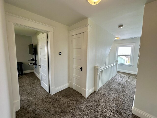 2034 Gittleson Rd, Rochelle, IL 61068 - hallway with dark colored carpet, baseboards, and an upstairs landing