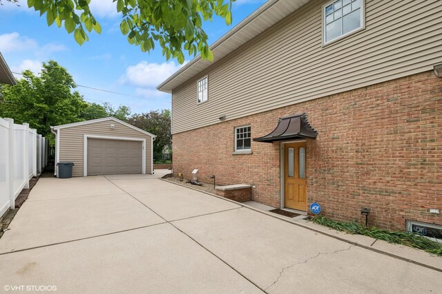 914 Meadowcrest Rd, La Grange Park, IL 60526 - view of property exterior featuring a detached garage, an outdoor structure, brick siding, and driveway