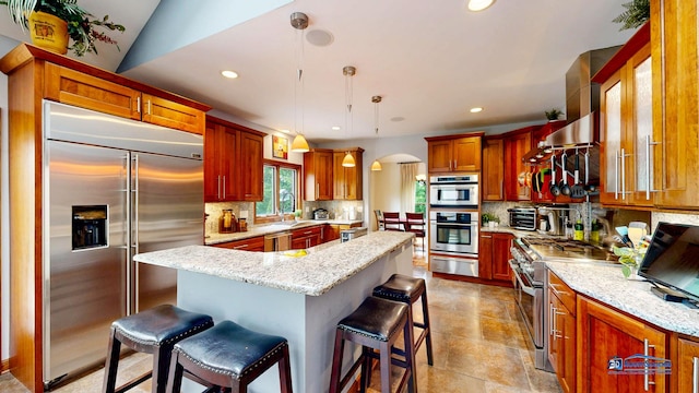 1535 S Douglas Ave, Arlington Heights, IL 60005 - kitchen with premium appliances, a warming drawer, a kitchen breakfast bar, backsplash, and arched walkways