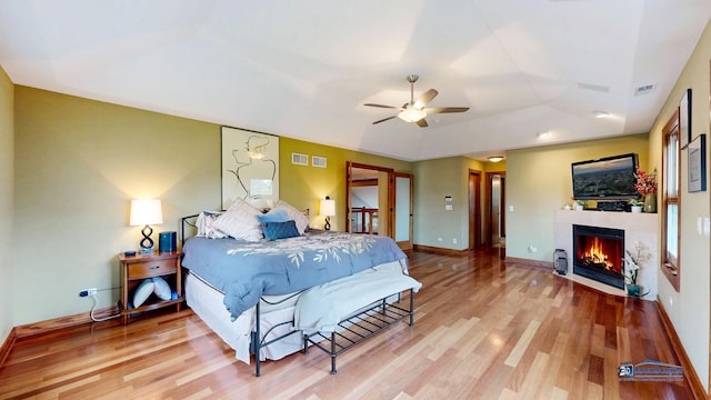1535 S Douglas Ave, Arlington Heights, IL 60005 - bedroom featuring wood finished floors, a raised ceiling, a glass covered fireplace, and ceiling fan