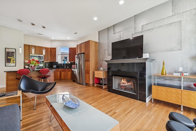 612 W Barry Ave Unit 3, Chicago, IL 60657 - living area with light wood-style flooring, a tiled fireplace, and recessed lighting