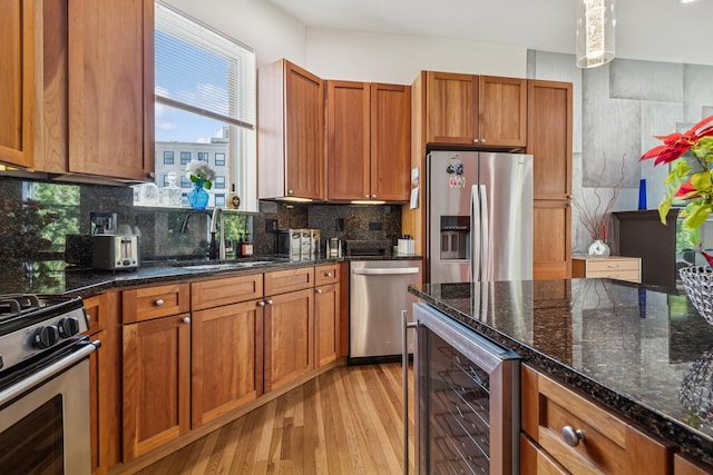 612 W Barry Ave Unit 3, Chicago, IL 60657 - kitchen with beverage cooler, stainless steel appliances, a sink, light wood-style floors, and brown cabinetry