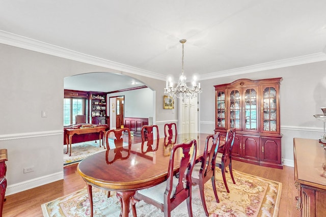 140 N Quincy St, Hinsdale, IL 60521 - dining room with arched walkways, light wood-style floors, crown molding, a chandelier, and baseboards