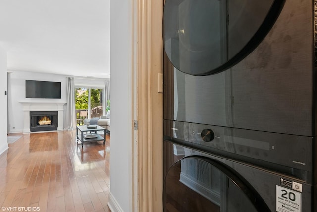 23 Foxcroft Rd Unit 235, Naperville, IL 60565 - laundry area with estacked washer and dryer, hardwood / wood-style flooring, and a lit fireplace