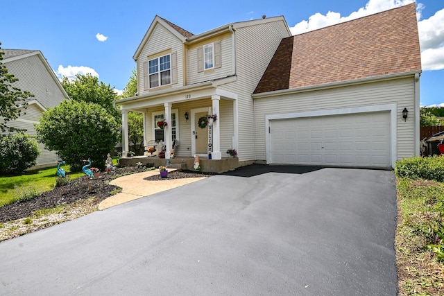 129 W Hampton Ct, Round Lake, IL 60073 - view of front of house with a porch, asphalt driveway, a garage, and roof with shingles