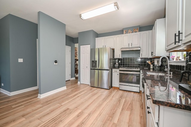 129 W Hampton Ct, Round Lake, IL 60073 - kitchen with appliances with stainless steel finishes, a sink, under cabinet range hood, dark stone counters, and backsplash