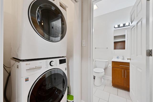 447 W 27th St, Chicago, IL 60616 - laundry area featuring stacked washer and clothes dryer, light tile patterned flooring, and baseboards