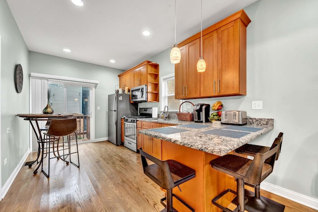 447 W 27th St, Chicago, IL 60616 - kitchen with stainless steel appliances, open shelves, brown cabinetry, a breakfast bar, and recessed lighting