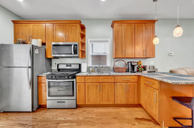 447 W 27th St, Chicago, IL 60616 - kitchen with appliances with stainless steel finishes, a sink, light stone countertops, light wood-style flooring, and brown cabinets