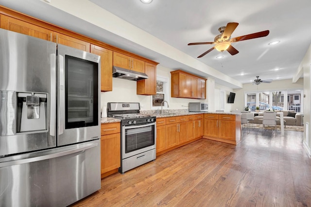 447 W 27th St, Chicago, IL 60616 - kitchen with appliances with stainless steel finishes, ceiling fan, a sink, under cabinet range hood, and light stone counters