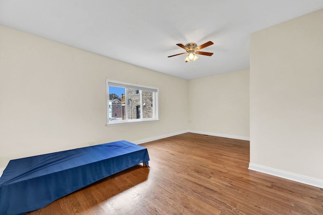 447 W 27th St, Chicago, IL 60616 - unfurnished bedroom with wood finished floors, baseboards, and a ceiling fan