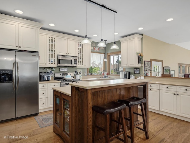 217 S Craig Pl, Lombard, IL 60148 - kitchen featuring stainless steel appliances, light countertops, light wood-type flooring, a breakfast bar, and recessed lighting