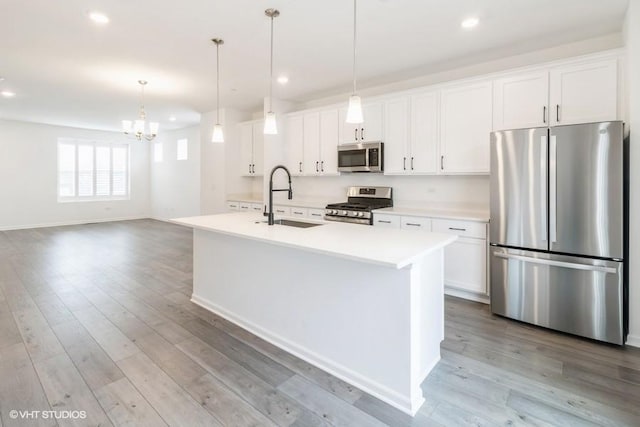 1533 Executive Way, Des Plaines, IL 60018 - kitchen featuring appliances with stainless steel finishes, a center island with sink, light countertops, a chandelier, and white cabinets