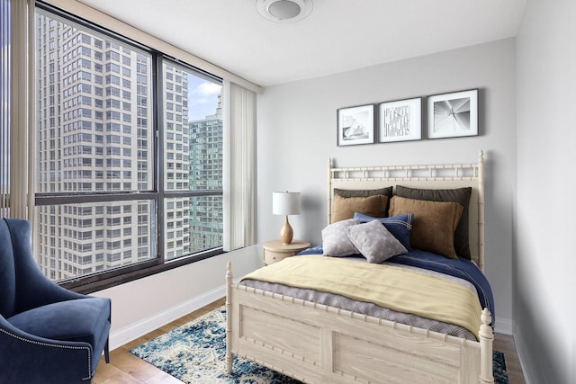 405 N Wabash Ave Unit 2204, Chicago, IL 60611 - bedroom featuring baseboards, wood finished floors, and a city view