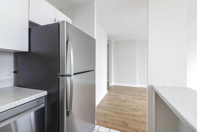 405 N Wabash Ave Unit 2204, Chicago, IL 60611 - kitchen with appliances with stainless steel finishes, light countertops, white cabinetry, light wood-type flooring, and baseboards