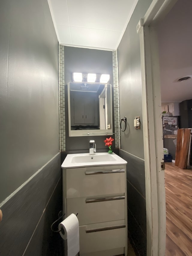 18020 Ridgeland Ave, Lansing, IL 60438 - half bathroom with vanity, ornamental molding, and wood finished floors