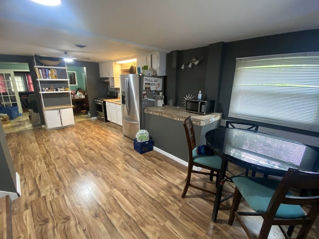 18020 Ridgeland Ave, Lansing, IL 60438 - kitchen featuring appliances with stainless steel finishes, white cabinetry, light wood-style flooring, light countertops, and baseboards