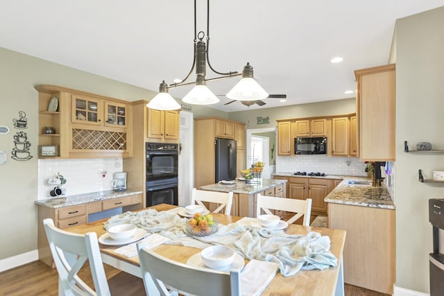 7N310 Ridge Line Rd, Saint Charles, IL 60175 - kitchen featuring black appliances, backsplash, a center island, light stone countertops, and decorative light fixtures