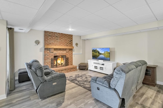 7N310 Ridge Line Rd, Saint Charles, IL 60175 - living room featuring light wood-style flooring, a paneled ceiling, a brick fireplace, and baseboards