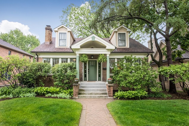 740 Wisner St, Park Ridge, IL 60068 - cape cod-style house with brick siding, a front yard, a chimney, and roof with shingles