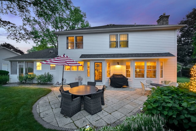 5234 Cedar Ct, Lisle, IL 60532 - back of house at dusk with a chimney, a patio, and a yard