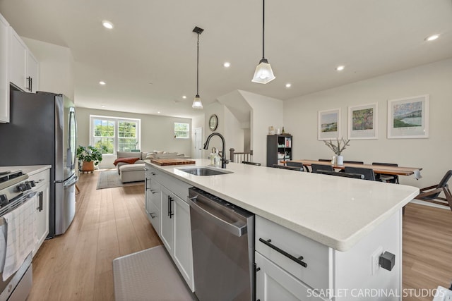 165 Canterbury Way, Lake Zurich, IL 60047 - kitchen with appliances with stainless steel finishes, open floor plan, white cabinets, a kitchen island with sink, and recessed lighting