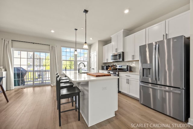 165 Canterbury Way, Lake Zurich, IL 60047 - kitchen with stainless steel appliances, white cabinets, light wood-type flooring, an island with sink, and recessed lighting