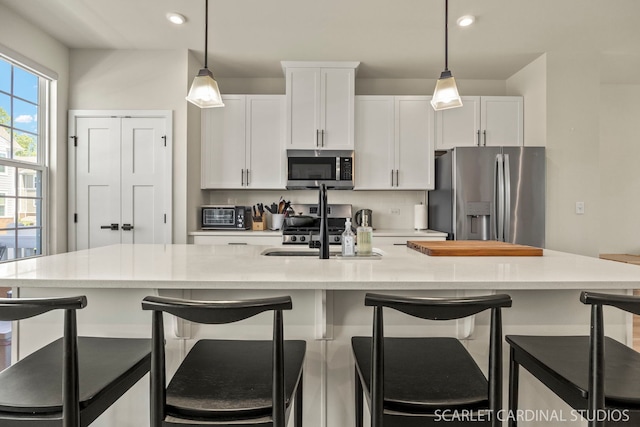 165 Canterbury Way, Lake Zurich, IL 60047 - kitchen with stainless steel appliances, white cabinetry, decorative light fixtures, an island with sink, and recessed lighting