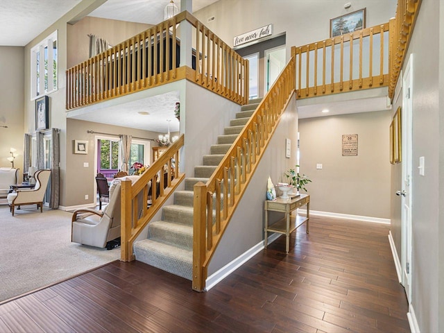 9104 E Weber Rd, Ridott, IL 61067 - stairway with a towering ceiling, baseboards, wood-type flooring, and a chandelier