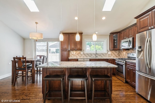 803 Pine St, Deerfield, IL 60015 - kitchen featuring appliances with stainless steel finishes, a skylight, a breakfast bar, tasteful backsplash, and recessed lighting