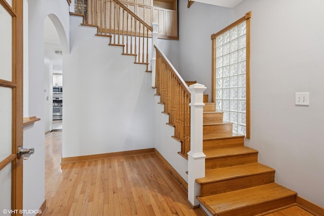 4308 N Whipple St, Chicago, IL 60618 - staircase featuring arched walkways, plenty of natural light, hardwood / wood-style floors, and baseboards