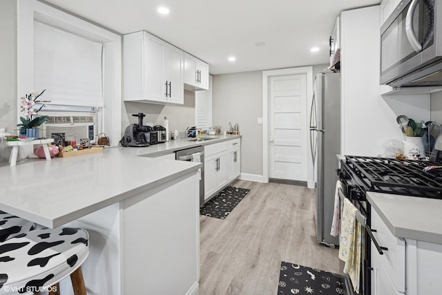 4308 N Whipple St, Chicago, IL 60618 - kitchen with stainless steel appliances, white cabinets, light wood-style flooring, and recessed lighting