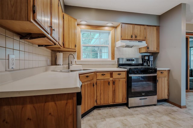 20541 E 2050 N Rd, Towanda, IL 61776 - kitchen featuring stainless steel gas stove, under cabinet range hood, a sink, decorative backsplash, and light countertops