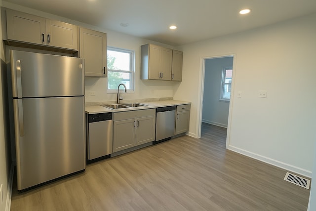 15117 2nd Ave, Phoenix, IL 60426 - kitchen with appliances with stainless steel finishes, a sink, gray cabinets, light wood-type flooring, and light countertops