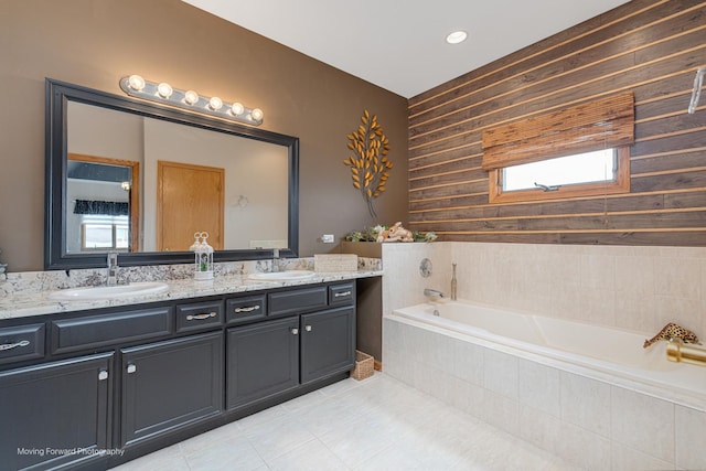 608 W N St, Peotone, IL 60468 - full bathroom with double vanity, tile patterned flooring, a garden tub, wood walls, and healthy amount of natural light