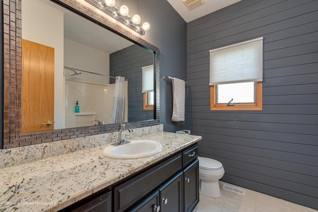 608 W N St, Peotone, IL 60468 - bathroom with vanity, toilet, wooden walls, a shower with shower curtain, and tile patterned floors
