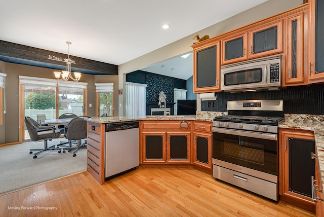608 W N St, Peotone, IL 60468 - kitchen featuring appliances with stainless steel finishes, a peninsula, a chandelier, light wood-style floors, and decorative light fixtures